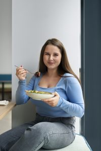 Mujer disfrutando de una comida equilibrada, relacionada con la nutrición personalizada y la saciedad.